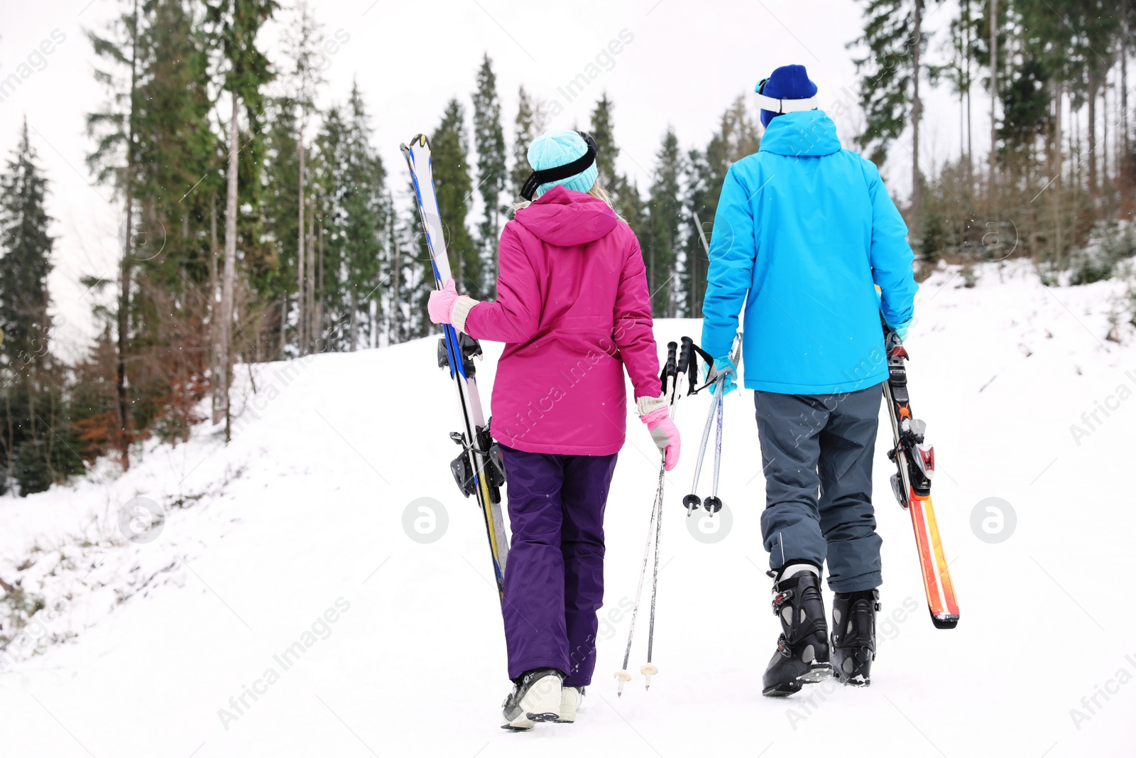 Photo of Couple of skiers on slope at resort. Winter vacation