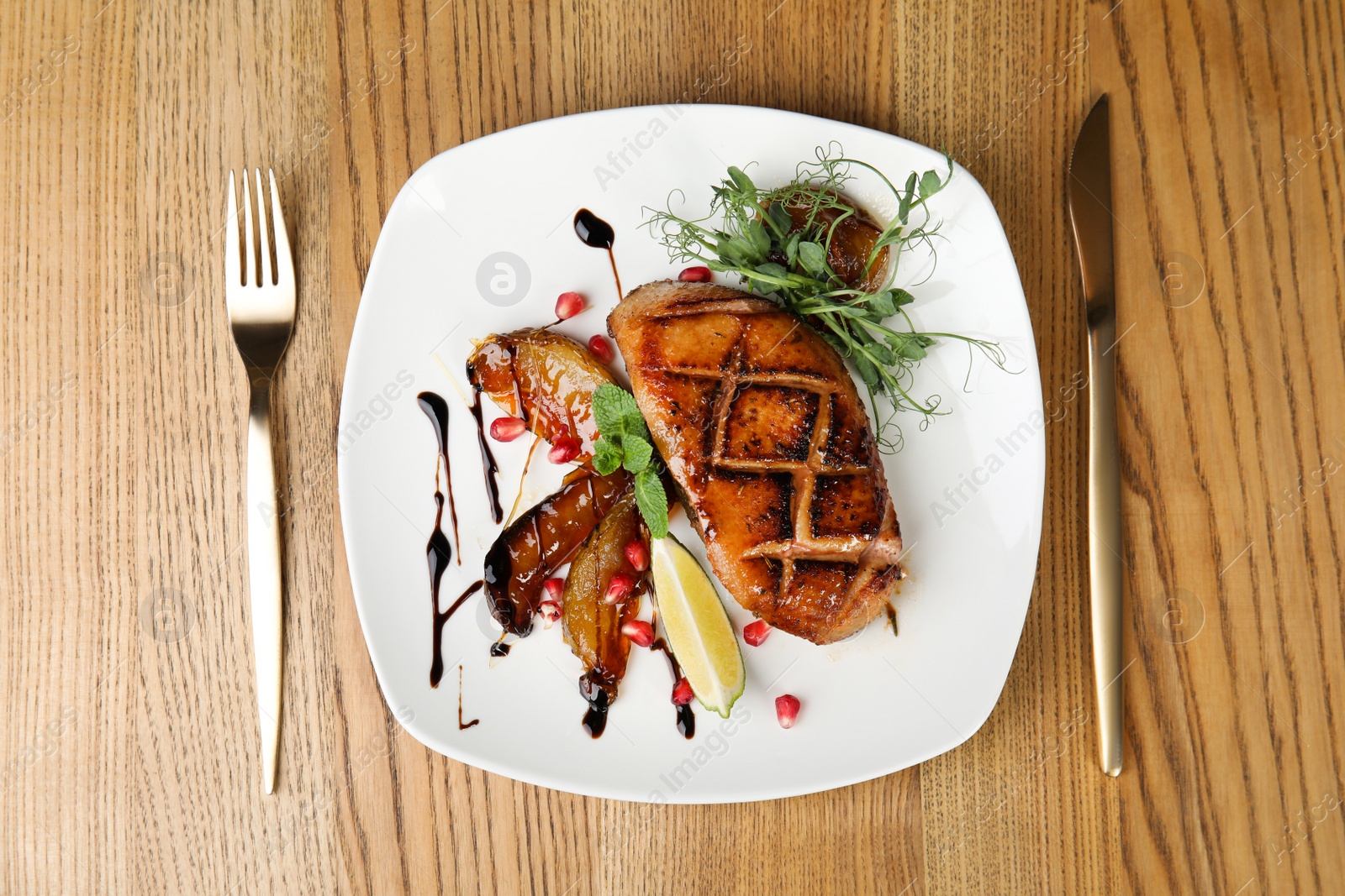 Photo of Delicious grilled duck breast served on wooden table, flat lay