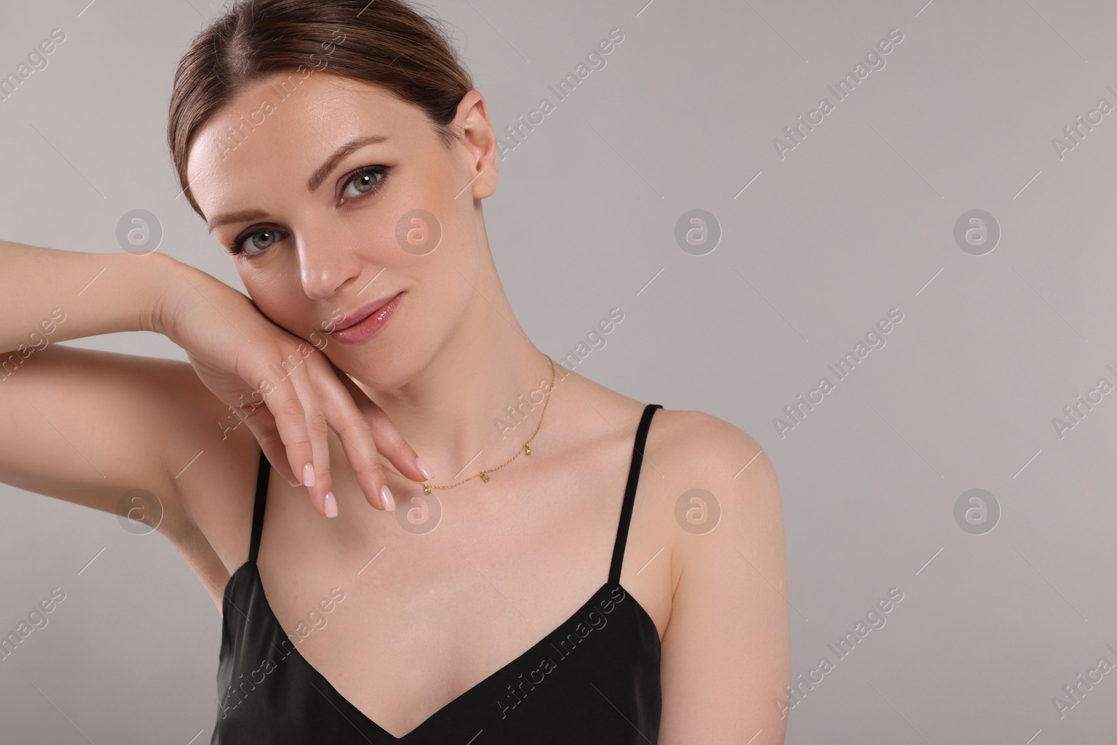 Photo of Beautiful woman with elegant necklace on light grey background. Space for text