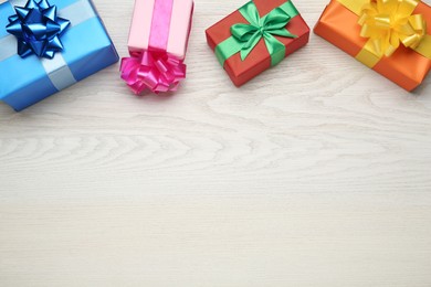 Photo of Many colorful gift boxes on white wooden table, flat lay. Space for text