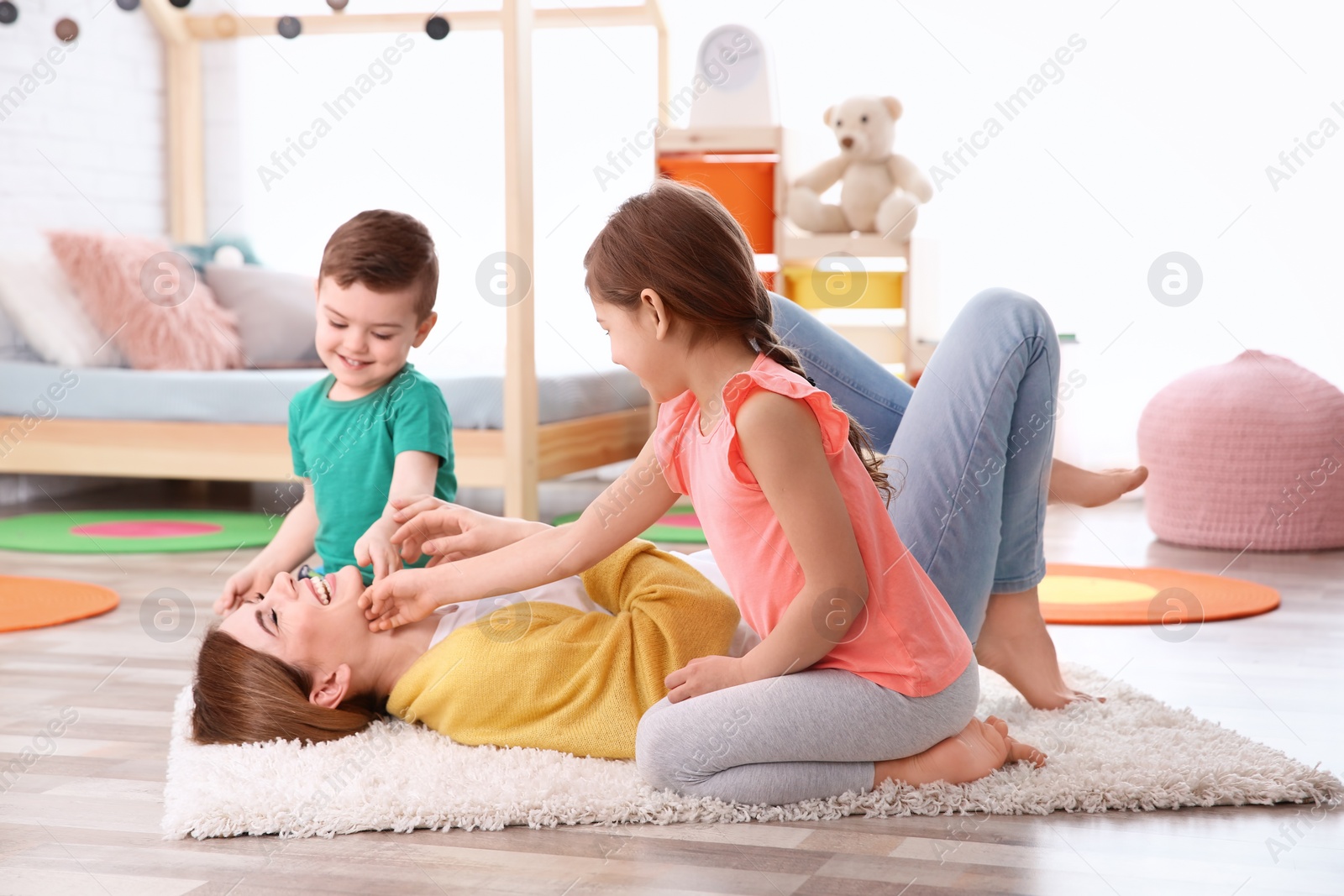 Photo of Nanny and little children playing at home