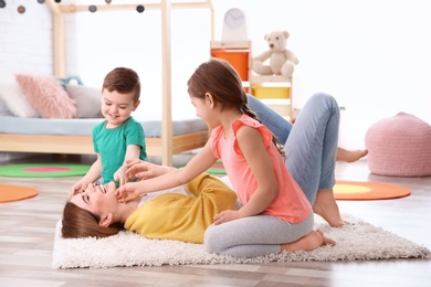 Photo of Nanny and little children playing at home