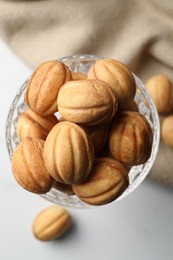 Delicious nut shaped cookies on white table, flat lay