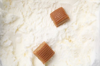 Photo of Caramel candies on tasty ice cream, top view