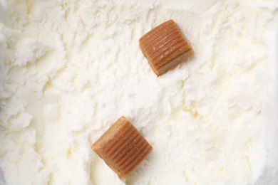 Caramel candies on tasty ice cream, top view