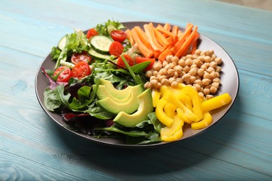 Balanced diet and vegetarian foods. Plate with different delicious products on light blue wooden table