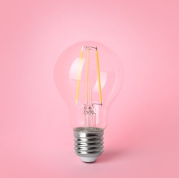 Vintage filament lamp bulb on pink background