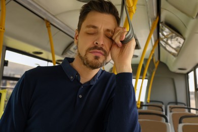 Tired man sleeping while riding in public transport