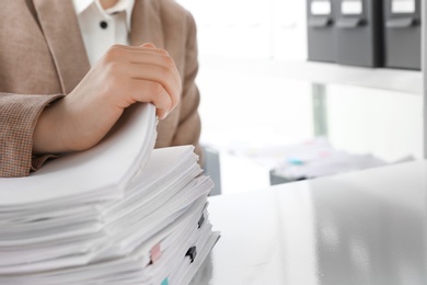 Photo of Woman working with documents in office, closeup. Space for text
