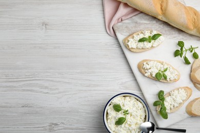 Bread with cottage cheese and basil on white wooden table, flat lay. Space for text