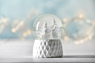 Photo of Snow globe with deer and trees on blurred background