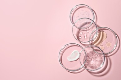 Photo of Many Petri dishes with cosmetic samples on pink background, flat lay. Space for text
