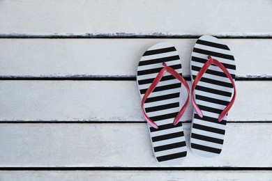 Photo of Stylish flip flops on white wooden table, flat lay. Space for text