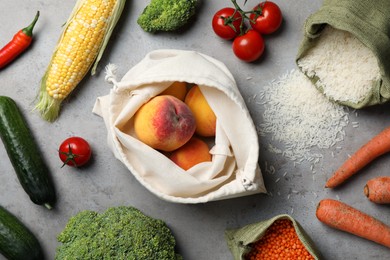 Photo of Different fresh vegetables, peaches and seeds on grey table