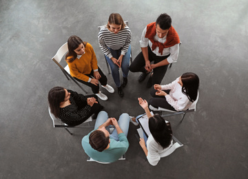 Psychotherapist working with patients in group therapy session, top view