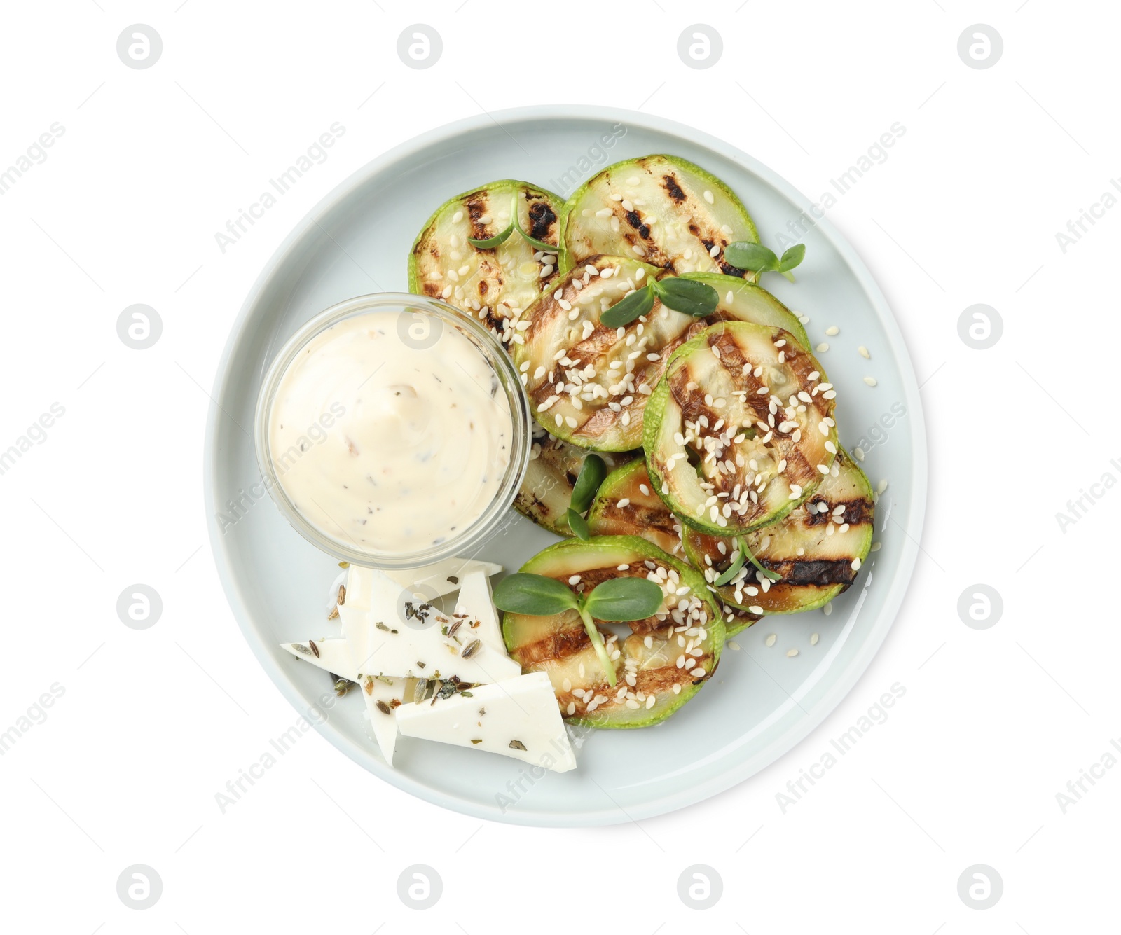 Photo of Delicious grilled zucchini slices served with sauce and cheese on white background, top view