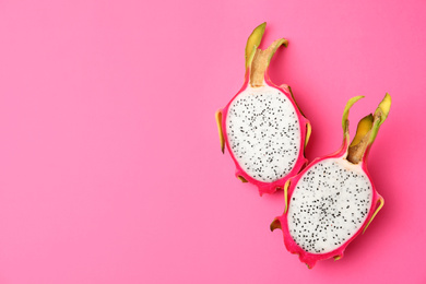 Photo of Halves of delicious ripe dragon fruit (pitahaya) on pink background, top view. Space for text