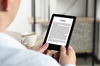 Image of Man reading book in electronic format using e-reader, closeup