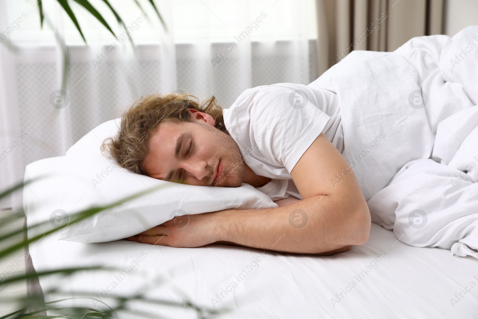 Photo of Handsome young man sleeping on pillow at home. Bedtime