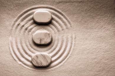 Image of Stones on sand with pattern, flat lay. Zen, meditation, harmony