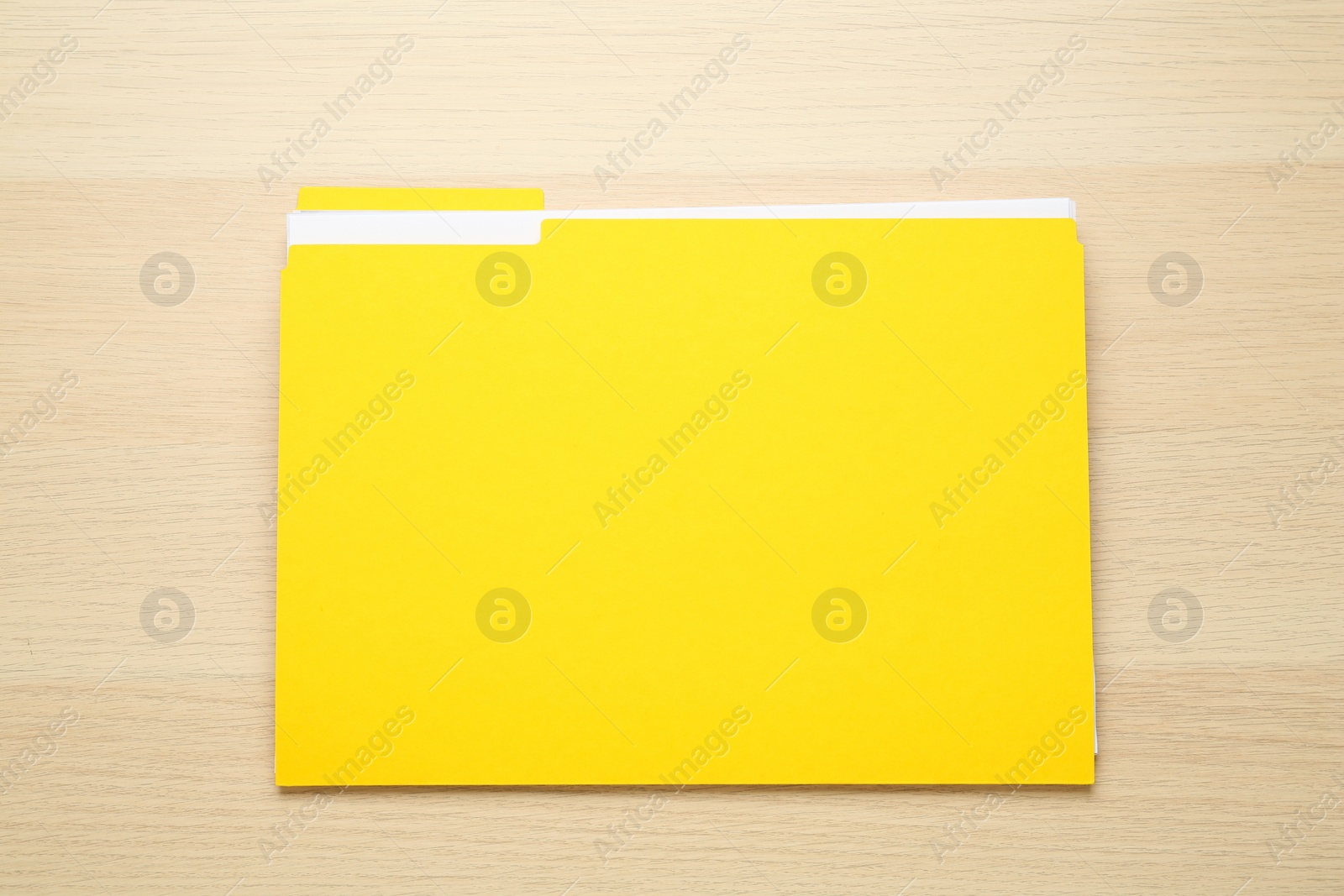 Photo of Yellow file with documents on wooden table, top view