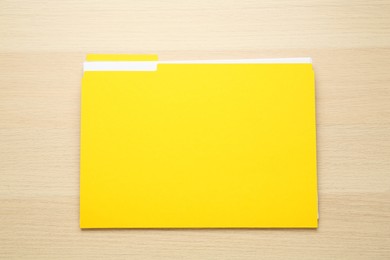 Photo of Yellow file with documents on wooden table, top view