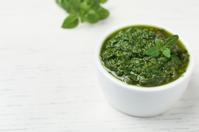 Homemade basil pesto sauce in bowl on table