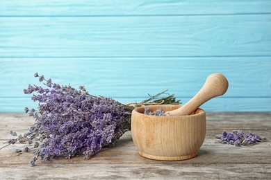 Photo of Mortar with lavender flowers on table. Ingredient for natural cosmetic