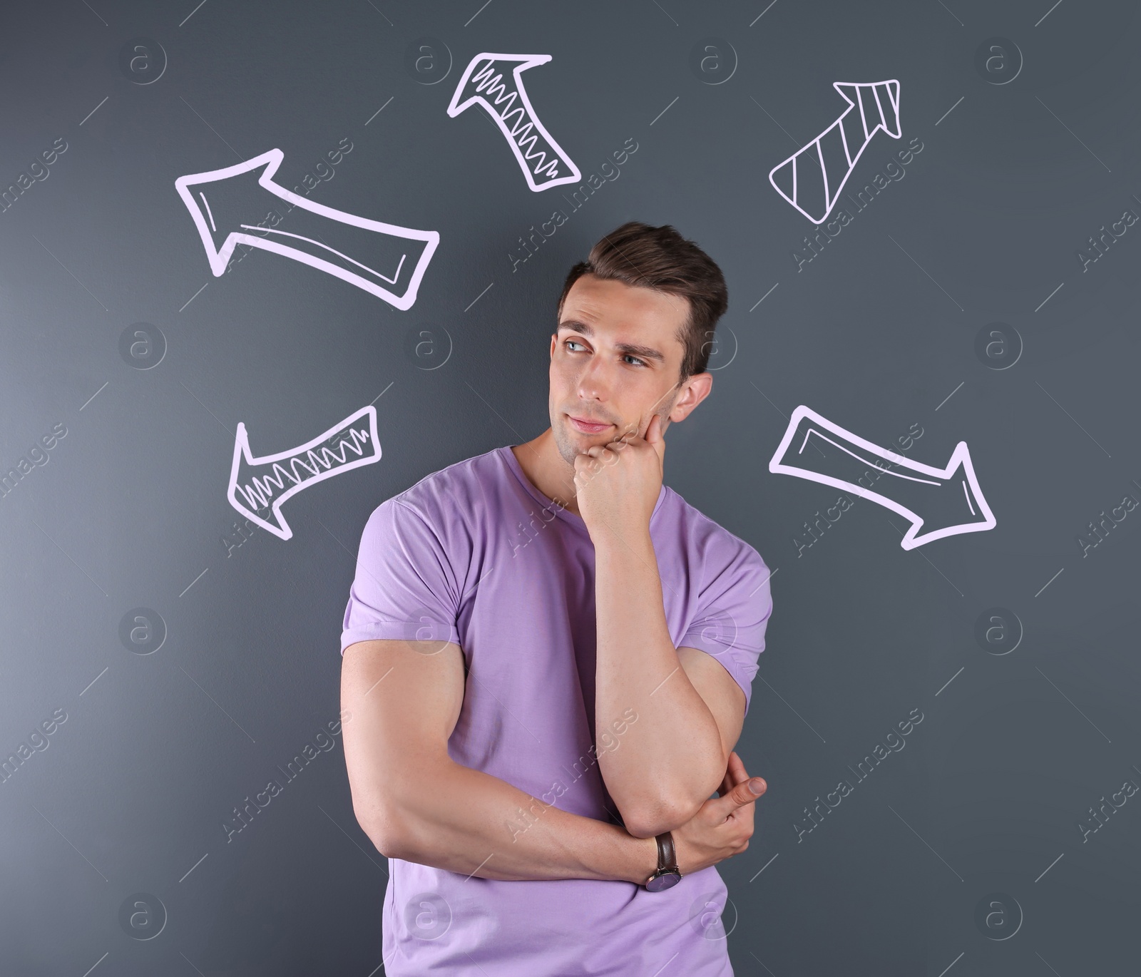 Image of Choice in profession or other areas of life, concept. Making decision, thoughtful young man surrounded by drawn arrows on grey background