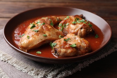 Photo of Tasty cooked rabbit meat with sauce and parsley on table, closeup