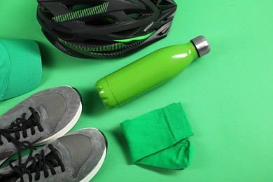 Photo of Different sports equipment on green background, flat lay