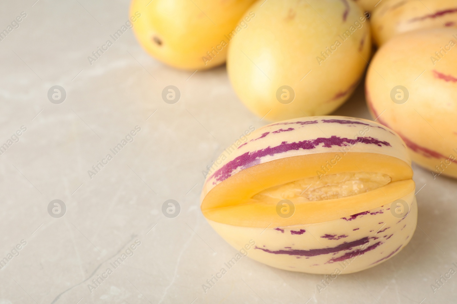 Photo of Cut and whole pepino melons on light table, space for text
