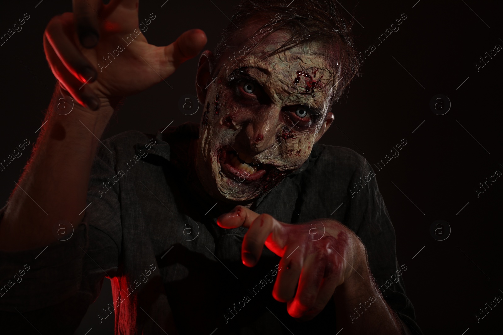 Photo of Scary zombie on dark background. Halloween monster