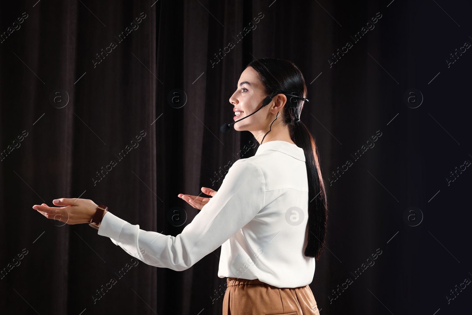 Photo of Motivational speaker with headset performing on stage