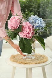 Photo of Woman with bouquet of beautiful hortensia flowers in living room, closeup