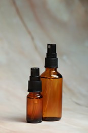 Photo of Bottles of organic cosmetic products on marbled background