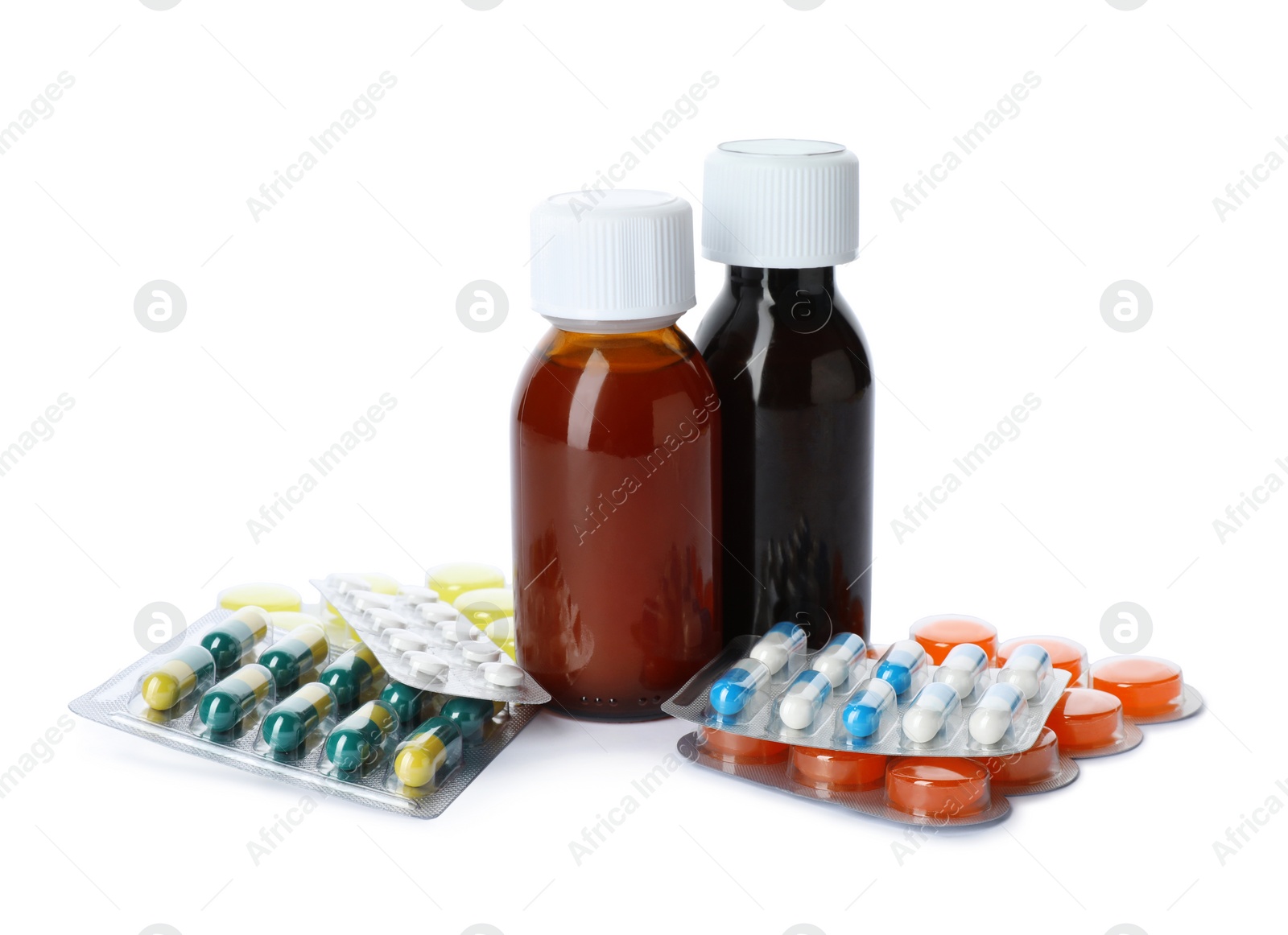 Photo of Bottles of cough syrup and different pills on white background