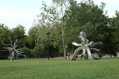 Picturesque view of beautiful park with metal figures on green grass