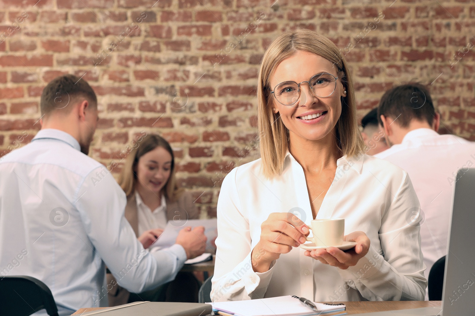 Photo of Businesswoman and her employees in office. Lady boss