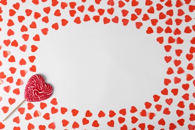 Composition with sweet lollipop and hearts on white background, top view. Space for text