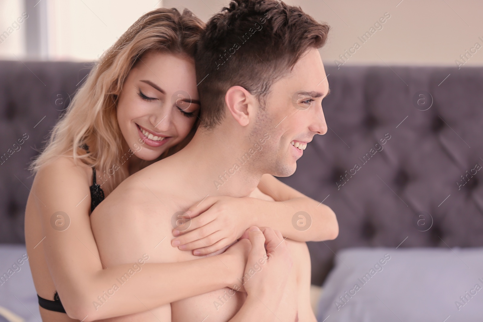 Photo of Sexy young couple being intimate on bed at home