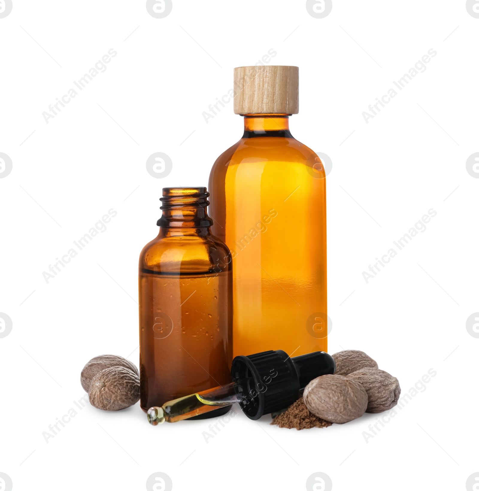 Photo of Bottles of nutmeg oil, nuts and pipette on white background