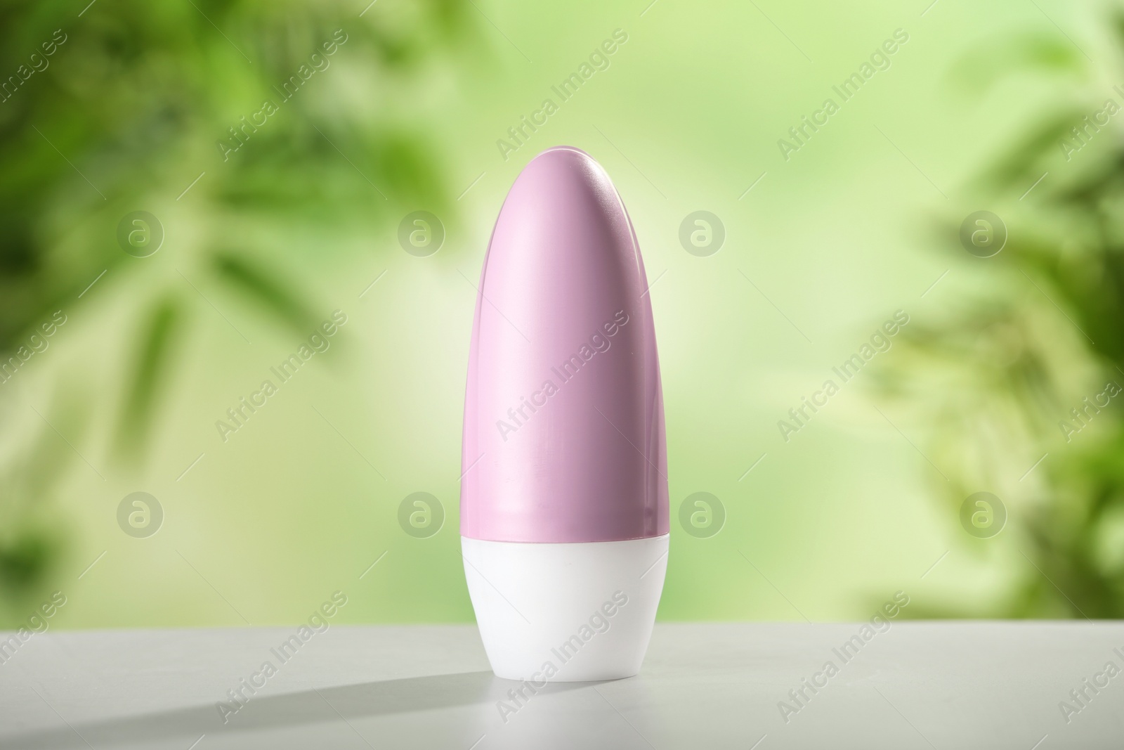 Photo of Deodorant container on white wooden table against blurred background