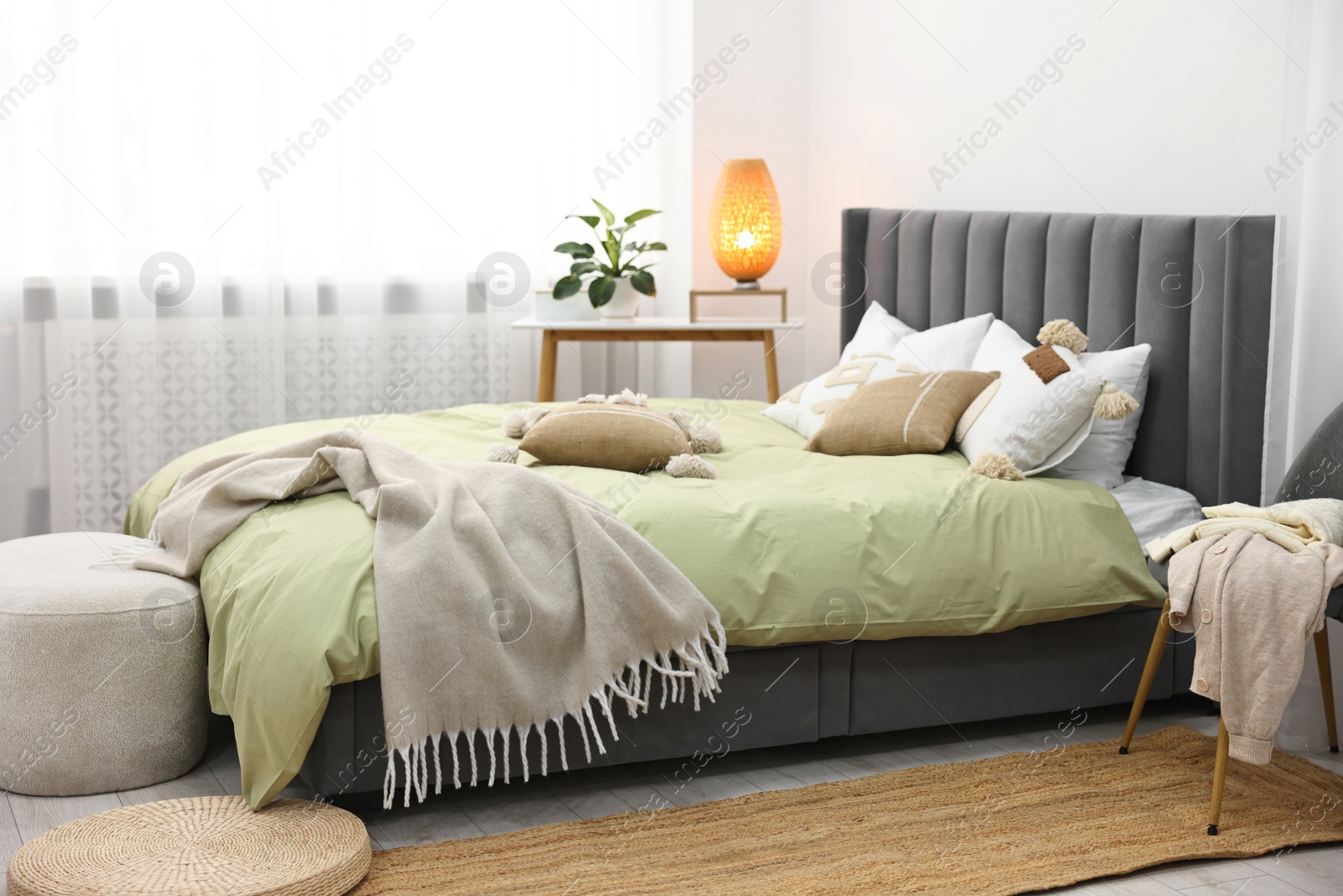 Photo of Soft plaid on bed in stylish bedroom