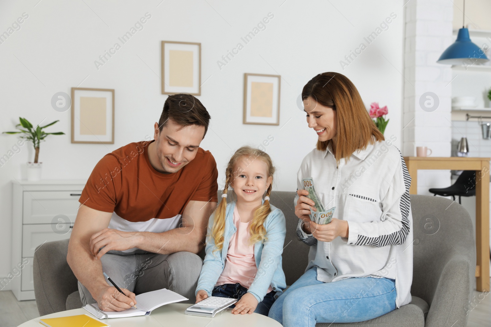 Photo of Happy family counting money on sofa at home