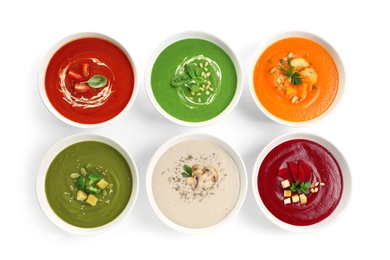 Various soups in bowls on white background, top view. Healthy food