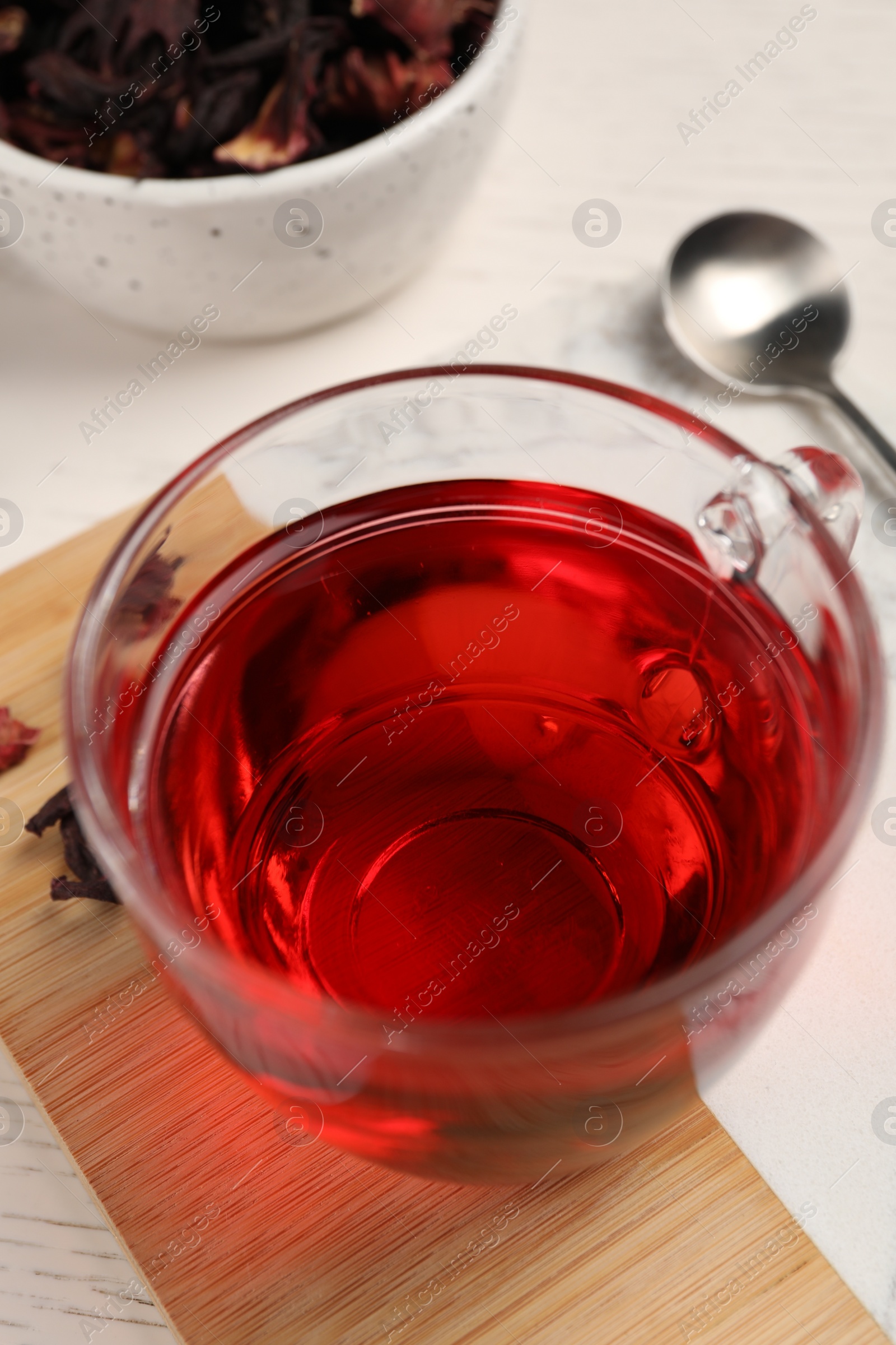 Photo of Cup of fresh hibiscus tea on wooden table, above view