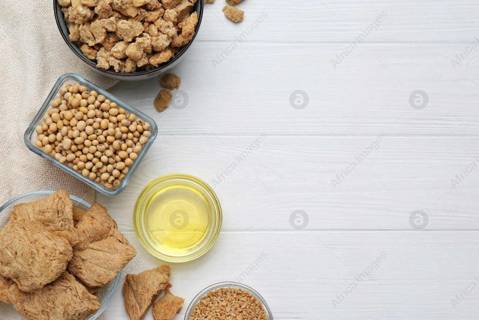 Photo of Different natural soy products on white wooden table, flat lay. Space for text