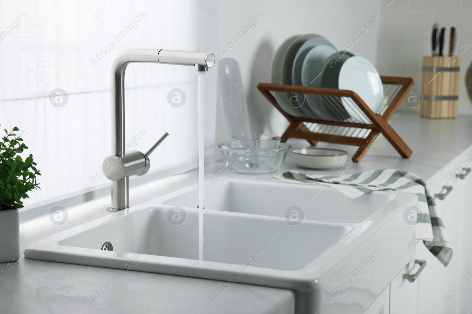 Photo of Stream of water flowing from tap in kitchen