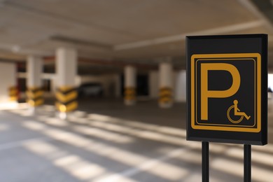 Image of Sign with wheelchair symbol in car parking garage, space for text 